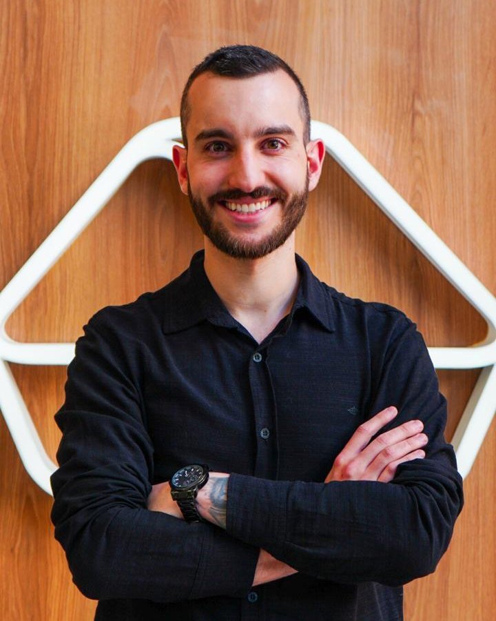 Kelme, consultor de consórcio de imóveis, sorrindo de braços cruzados